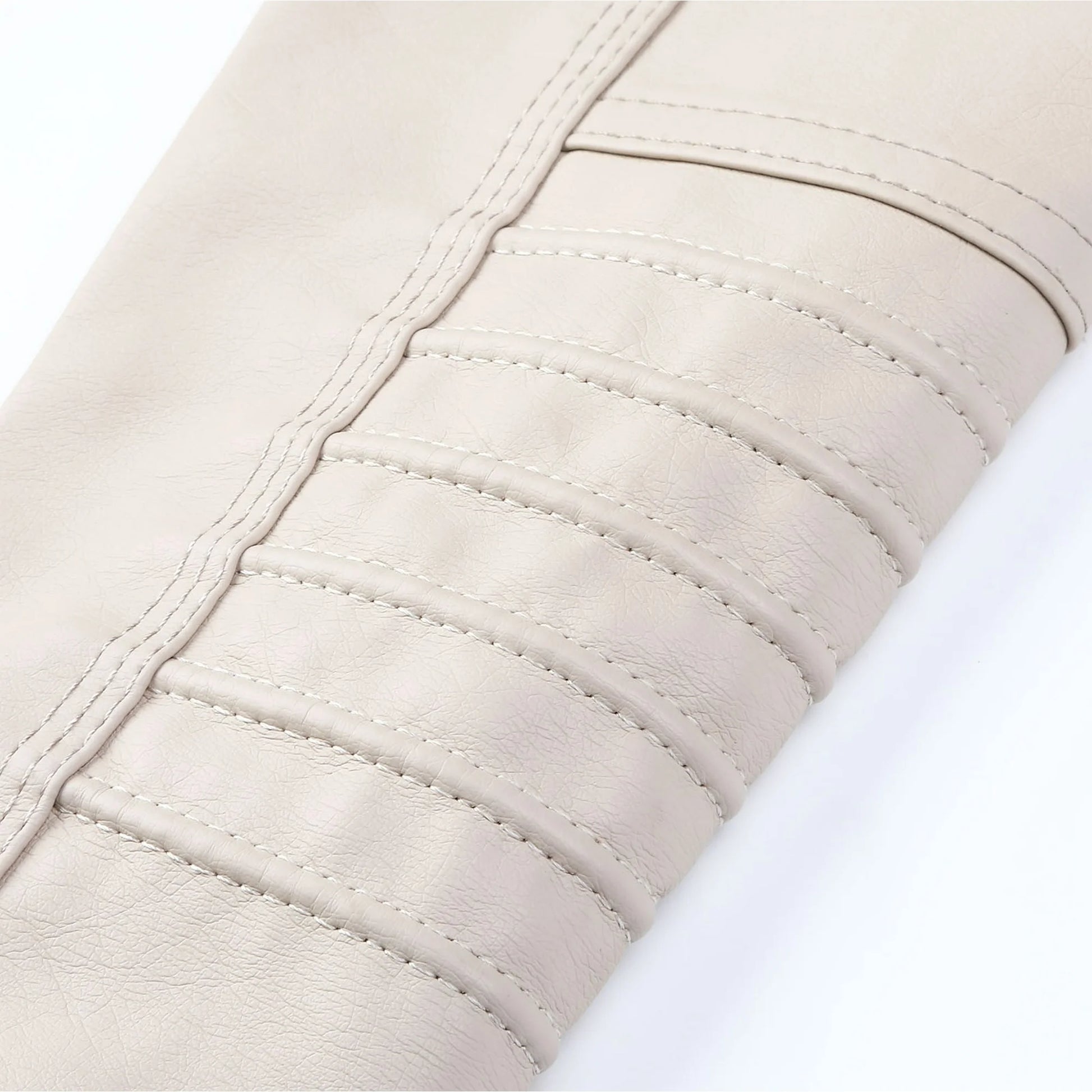 Close-up of beige quilted fabric with visible stitching on a white background