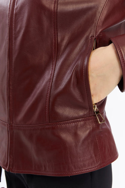 Close-up of a maroon leather jacket with a zipper on a white background