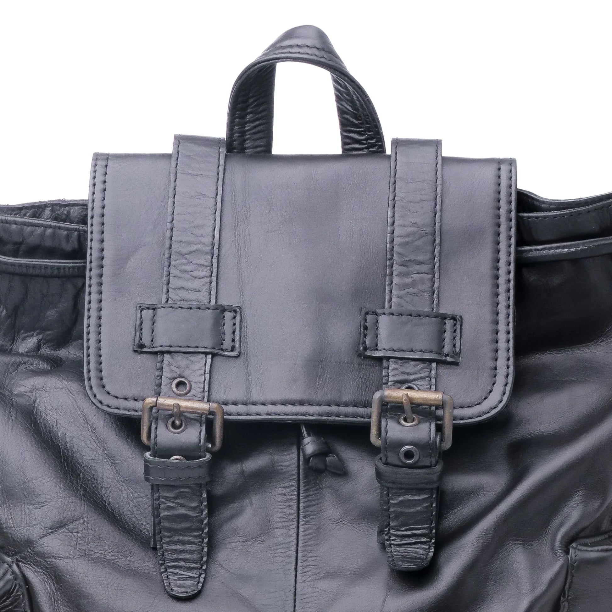 Black leather satchel bag with straps on a black leather surface